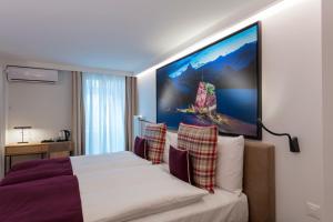 苏黎世Fred Hotel Leonhardstrasse - Self Check-in的酒店客房设有一张床,墙上挂着一幅大画