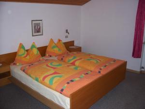 拉伊翁迈洛夫酒店的一间卧室配有一张大床和色彩缤纷的被子