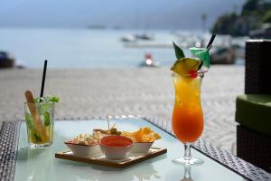 阿斯科纳新艾尔维泽酒店的海滩上的一张桌子,上面放着饮料和一盘食物