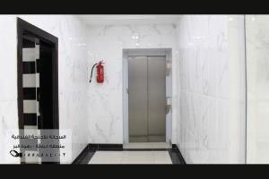 巴哈المرجانة للشقق المفروشه للعائلات Al Murjana Furnished Apartments for Families的设有带步入式淋浴间的浴室。 红色灭火器