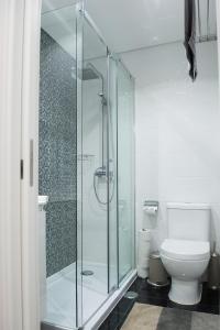 塞辛布拉Tropical house的一间带玻璃淋浴和卫生间的浴室