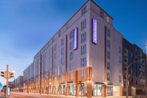 慕尼黑慕尼黑馨乐庭服务公寓酒店的一面有紫色标志的建筑
