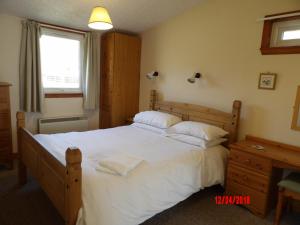因弗莫里斯顿Forest Glen Holiday Park的卧室配有一张带白色床单和枕头的大床。