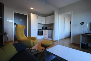 Tananger坦纳戈公寓酒店的带沙发和椅子的客厅以及厨房。