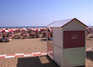 卡奥莱Giovanna Rooms的海滩上的一座建筑,上面有红白的遮阳伞