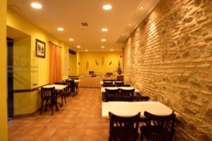 托莱多尤里科酒店的一间设有桌椅的石墙餐厅