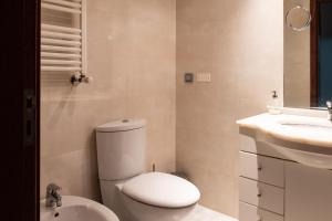 里斯本Apartamento Arrabida的白色的浴室设有卫生间和水槽。