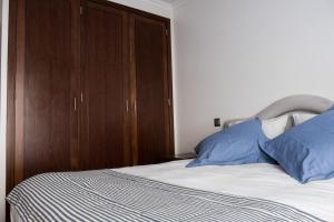 里斯本Apartamento Arrabida的一间卧室配有一张木柜床