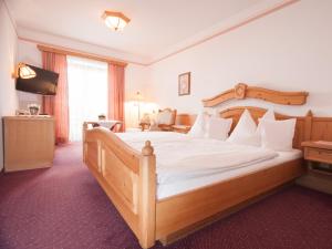 大格迈因盖斯特豪弗斯特恩维尔特酒店的一间卧室配有一张大木床和电视。