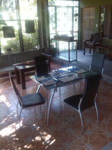 CurubandéTiquisia Lodge的客厅里设有玻璃桌和椅子