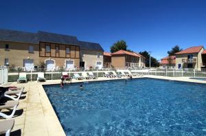 蒙蒂尼亚克欧黛丽丝拉莫迪慕南度假酒店的一座带椅子和人手的大型游泳池