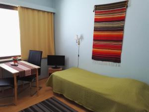 罗瓦涅米乌塔旅馆的一间卧室配有一张床和一张书桌,并铺有色彩缤纷的地毯。