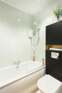 斯特兰拉尔海王星休息住宿加早餐旅馆的带淋浴、卫生间和浴缸的浴室