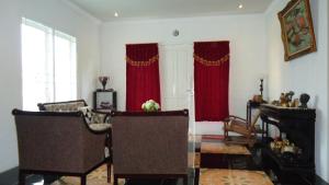 展玉Villa Cipanas的客厅配有红色窗帘和钢琴