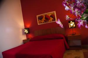 萨利切萨伦蒂诺L'IMPERATORE的红色卧室配有一张床和两盏灯
