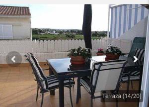 托里代巴拉Casa _pareada con piscina y jardin privado的阳台上的黑色餐桌和椅子