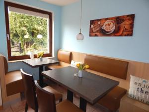 维斯马Pension am Burgwall的餐厅设有2张桌子和椅子以及窗户。