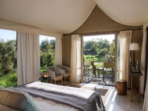 提姆巴瓦提禁猎区西姆拜瓦提河酒店的一间卧室设有一张床和一个滑动玻璃门