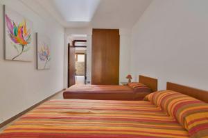 莱乌卡Girasole by BarbarHouse的宿舍间的三张床,配有色彩缤纷的地毯