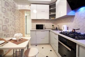 戈梅利PaulMarie Apartments on Kozhara的厨房配有白色橱柜和炉灶烤箱。