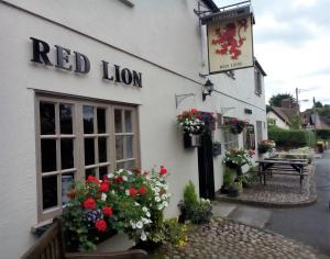 Little BudworthRed Lion Inn的一座红色狮子楼,前面有鲜花