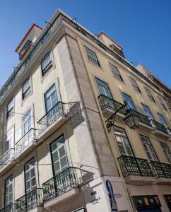 里斯本里斯本拜萨服务公寓式酒店的一座高大的建筑,旁边设有阳台