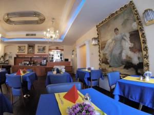 维也纳卓越住宿加早餐旅馆的餐厅设有蓝色的桌子,墙上挂着一幅大画