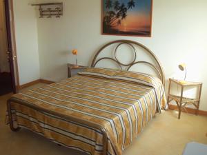 佩斯基耶拉德加达Albergo Marsari的卧室里带条纹毯子的床