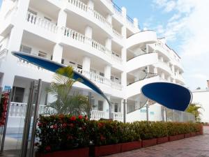 吉拉尔多特桑巴酒店的前面有蓝色伞的白色建筑