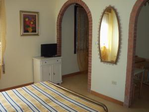 佩斯基耶拉德加达Albergo Marsari的卧室配有一张床,墙上设有镜子