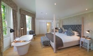 斯劳斯托克广场酒店的一间卧室配有一张床、一个浴缸和一个浴缸