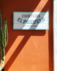 塔里法科尔蒂霍萨尔瓦多波苏埃罗酒店的一只带仙人掌的墙边的标志