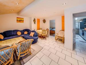 蒙绍Gästehaus Eschbach的一间带蓝色沙发的客厅和一间厨房