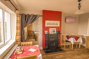 杜林The Pipers Rest的客厅设有红色的墙壁、桌子和壁炉