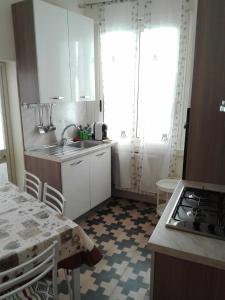 加拉蒂纳Casa vacanze Marilena的厨房配有白色橱柜、水槽和桌子