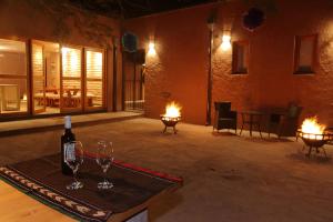 圣佩德罗·德·阿塔卡马La Casa de Pascual Andino的一间房间,配有两杯酒和一瓶葡萄酒