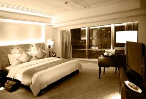 上海上海百乐门精品酒店的一间卧室配有一张床、一张书桌和一个窗户。