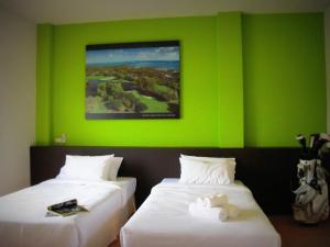 甲米镇高尔夫球练习场棕榈度假酒店的绿墙客房的两张床