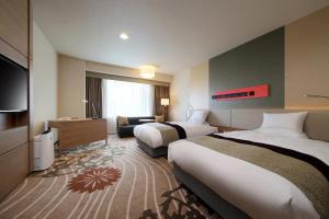 山形市山形大都会酒店的酒店客房设有两张床和电视。