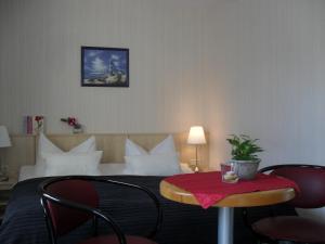 吕根岛上的维克Hotel-Pension Zur Mole的酒店客房配有一张带桌椅的床。