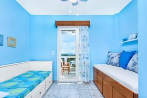 耶拉基尼Gerakini Sunshine Holiday Homes的一间蓝色卧室,配有一张床和一个阳台