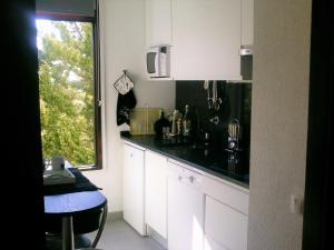 特罗亚Apartment Troia Garden的厨房配有白色橱柜和黑色台面