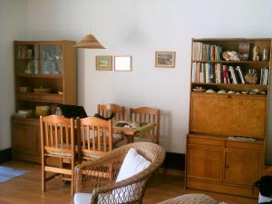 特罗亚Apartment Troia Garden的客厅配有桌椅和书架
