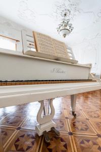 库塔伊西The Grand Piano Villa的天花板房间的一架白色钢琴