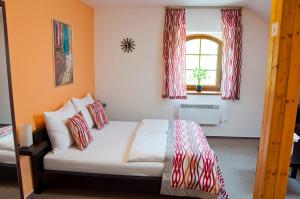兹诺伊莫Penzion Krásný sklep的一间卧室配有红色和白色枕头的床