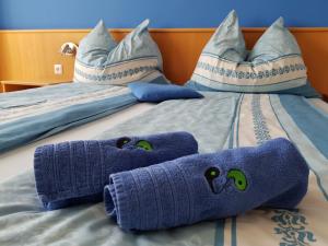滨湖波德斯多夫Gästehaus Lokalaugenschein的一张带蓝色毛巾和枕头的床