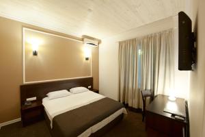 敖德萨日内瓦度假酒店的配有一张床和一张书桌的酒店客房