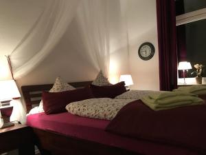 Leezdorf利兹道夫酒店的一间卧室配有一张床、两盏灯和一个时钟