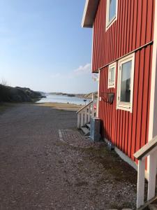 王室港Seaview Cottage Solvik - Kungshamn的水体旁边的红色建筑