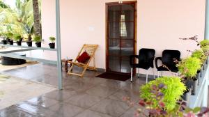 科钦Homested Homestay Fort Kochi的一间设有椅子和桌子的房间,还有一些植物